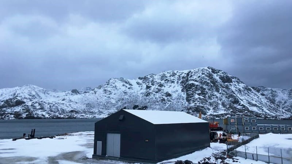 En isolert talthall fra Hallgruppen står i et snødekt miljø med fjell i bakgrunnen.
