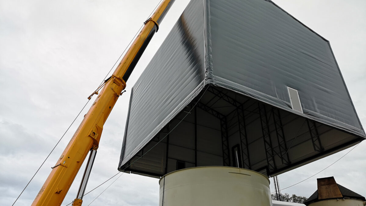 Hallgruppen bruker en kran for å montere en isolert talthall på et industriområde.