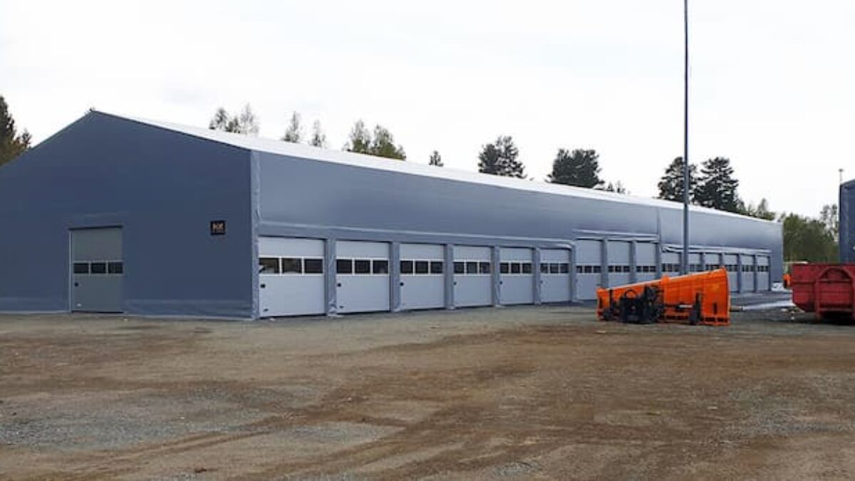 Hallgruppen har oppført en lang isolert talthall med flere porter på en gruslagt plass.