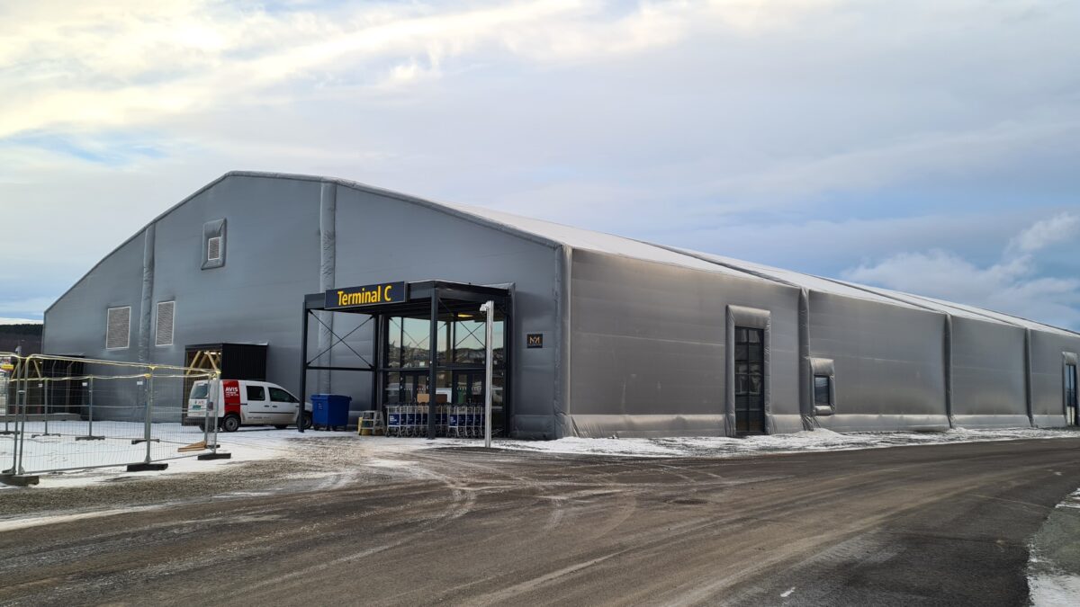 En stor isolert talthall bygget av Hallgruppen fungerer som en terminal i et vinterlandskap.